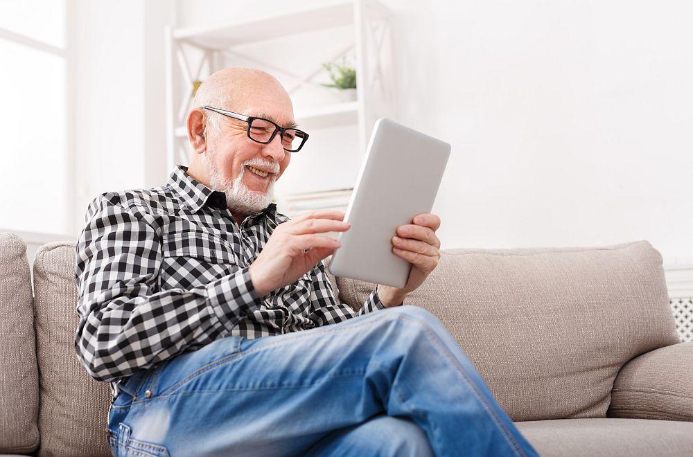 Elderly man looking at his tablet